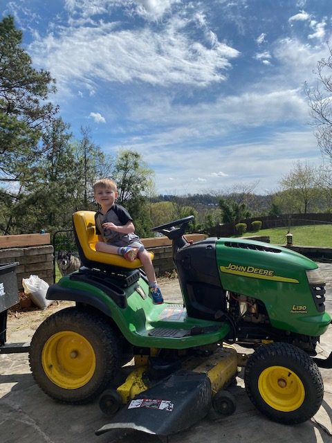 Kaison riding John Deere tractor in Smoky Mountains